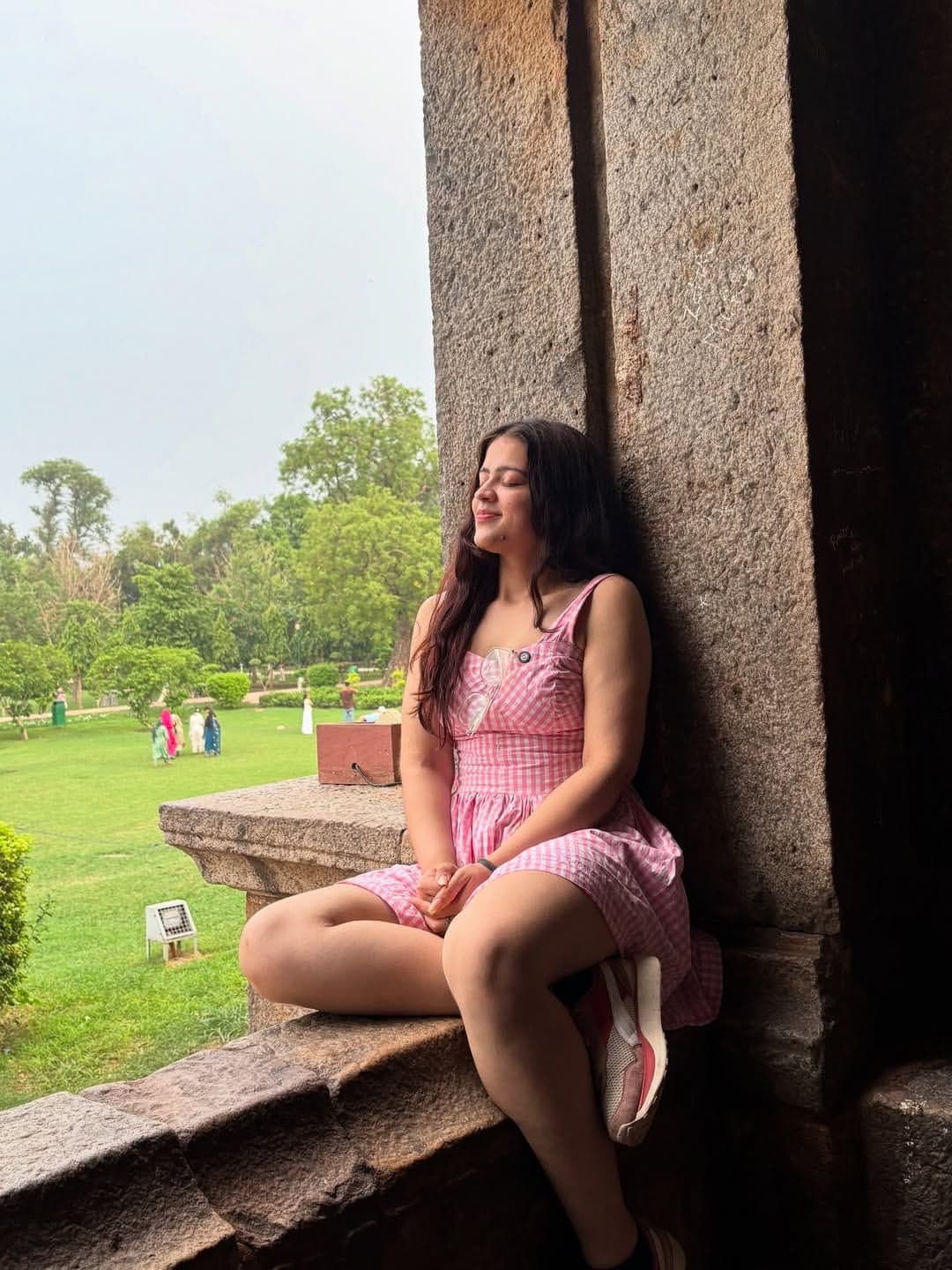 Priya sitting in the arch of an old monument in Delhi