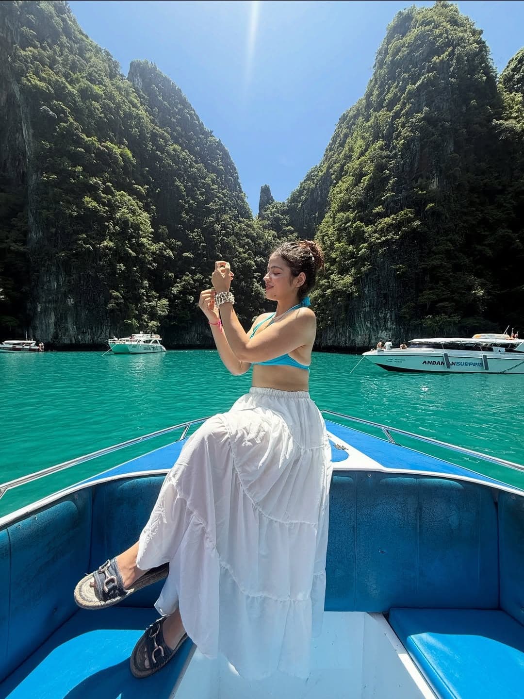 Priya on a boat between limestone cliffs in Thailand